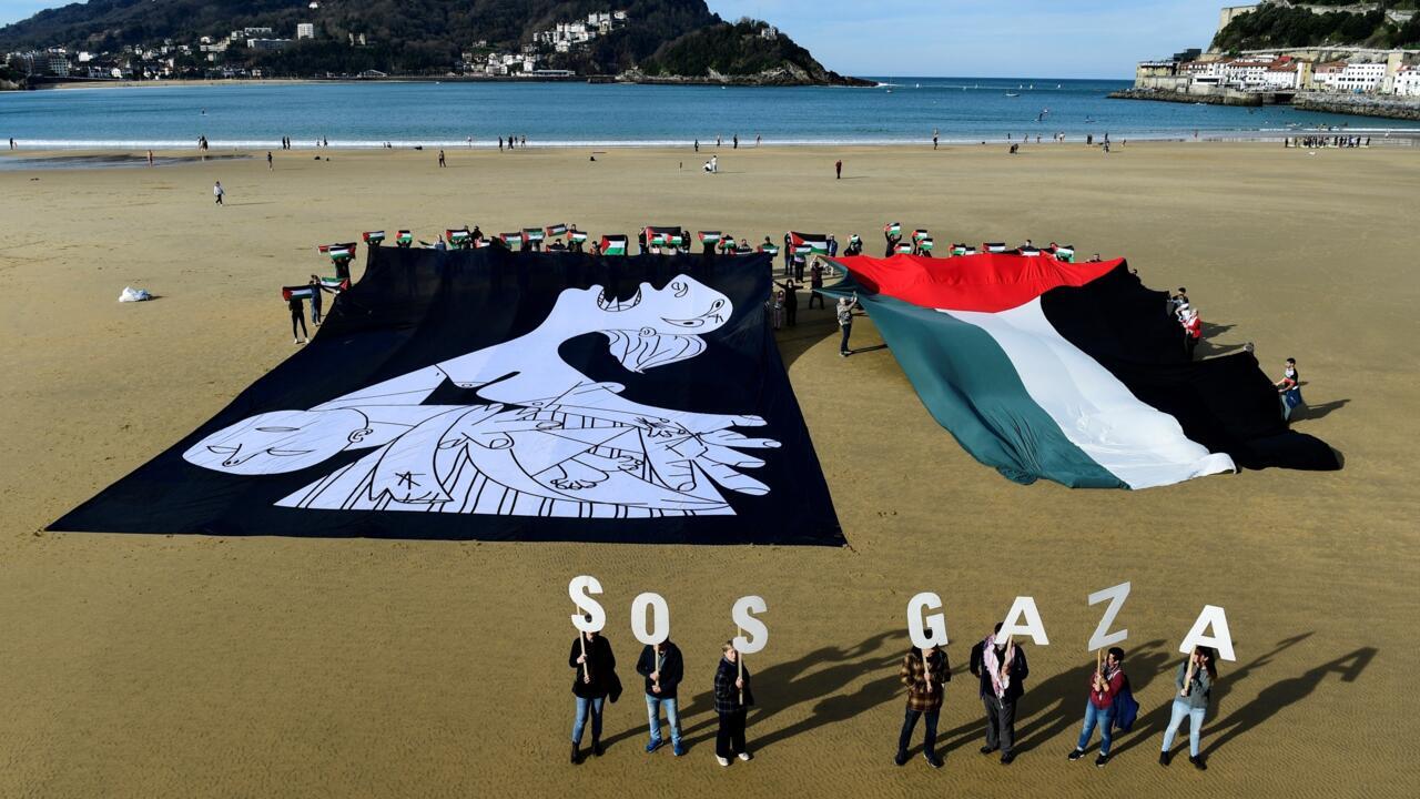 Demonstrators hold a canvas with a detail of Pablo Picasso's "Guernica" and a giant Palestinian flag during a protest in the Basque city of San Sebastian on January 28, 2024. © Ander Gillenea, AFP